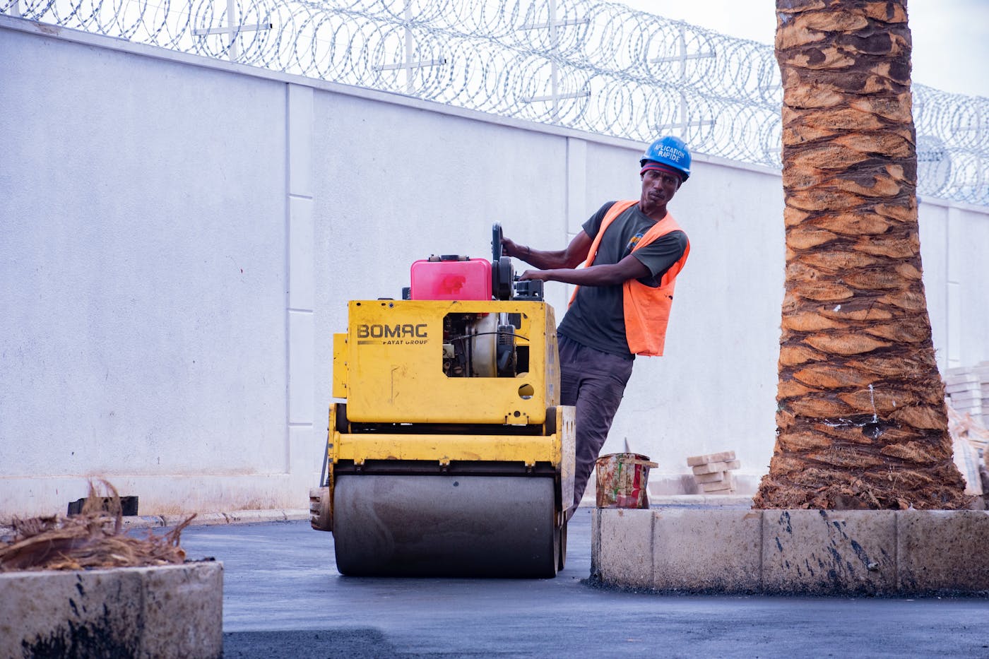 Contractor operating an asphalt roller while repairing a Perth driveway surface